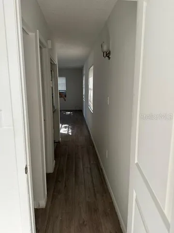 a view of a hallway with wooden floor