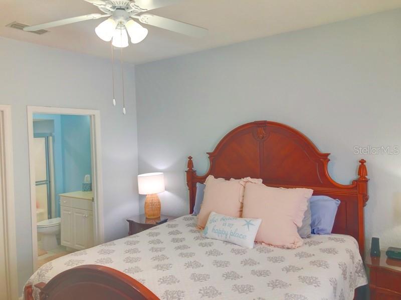 1211 Hot Springs Point Englewood, FL 34223 - Photo 15 of 30 a bedroom with a bed and a chandelier