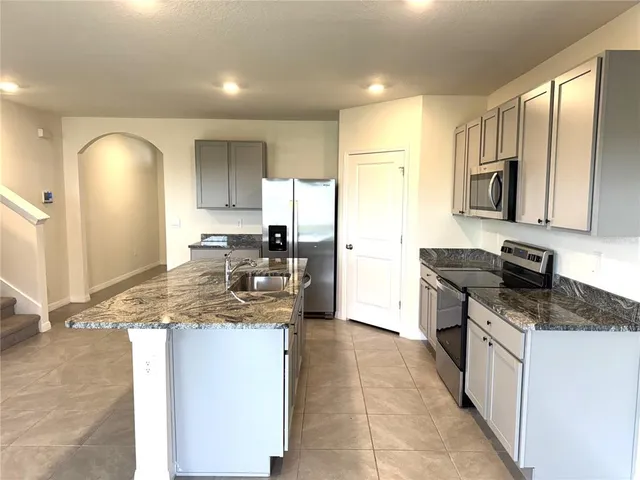 a kitchen with a sink a counter top space appliances and cabinets