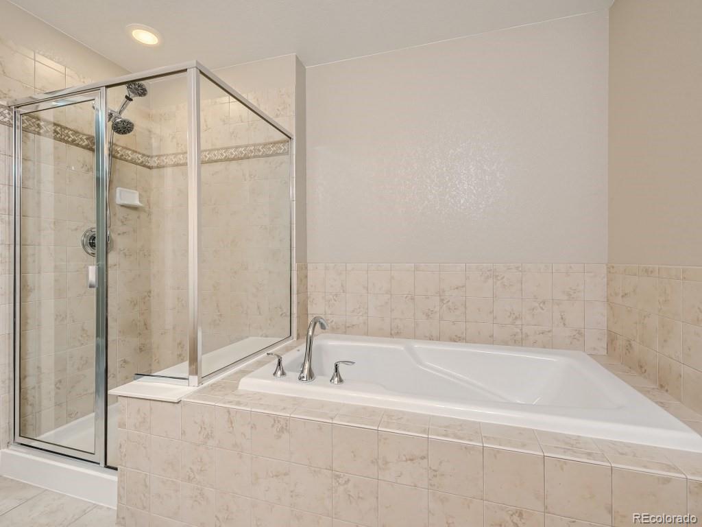 950 Elmhurst Drive, Unit E Highlands Ranch, CO 80129 - Photo 16 of 28 a bathroom with a bathtub and a shower