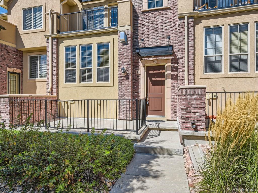 950 Elmhurst Drive, Unit E Highlands Ranch, CO 80129 - Photo 2 of 28 front view of a brick house with a large windows