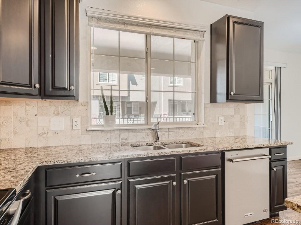 950 Elmhurst Drive, Unit E Highlands Ranch, CO 80129 - Photo 10 of 28 a kitchen with granite countertop a sink and a window