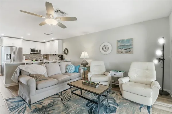 a living room with furniture kitchen view and a chandelier