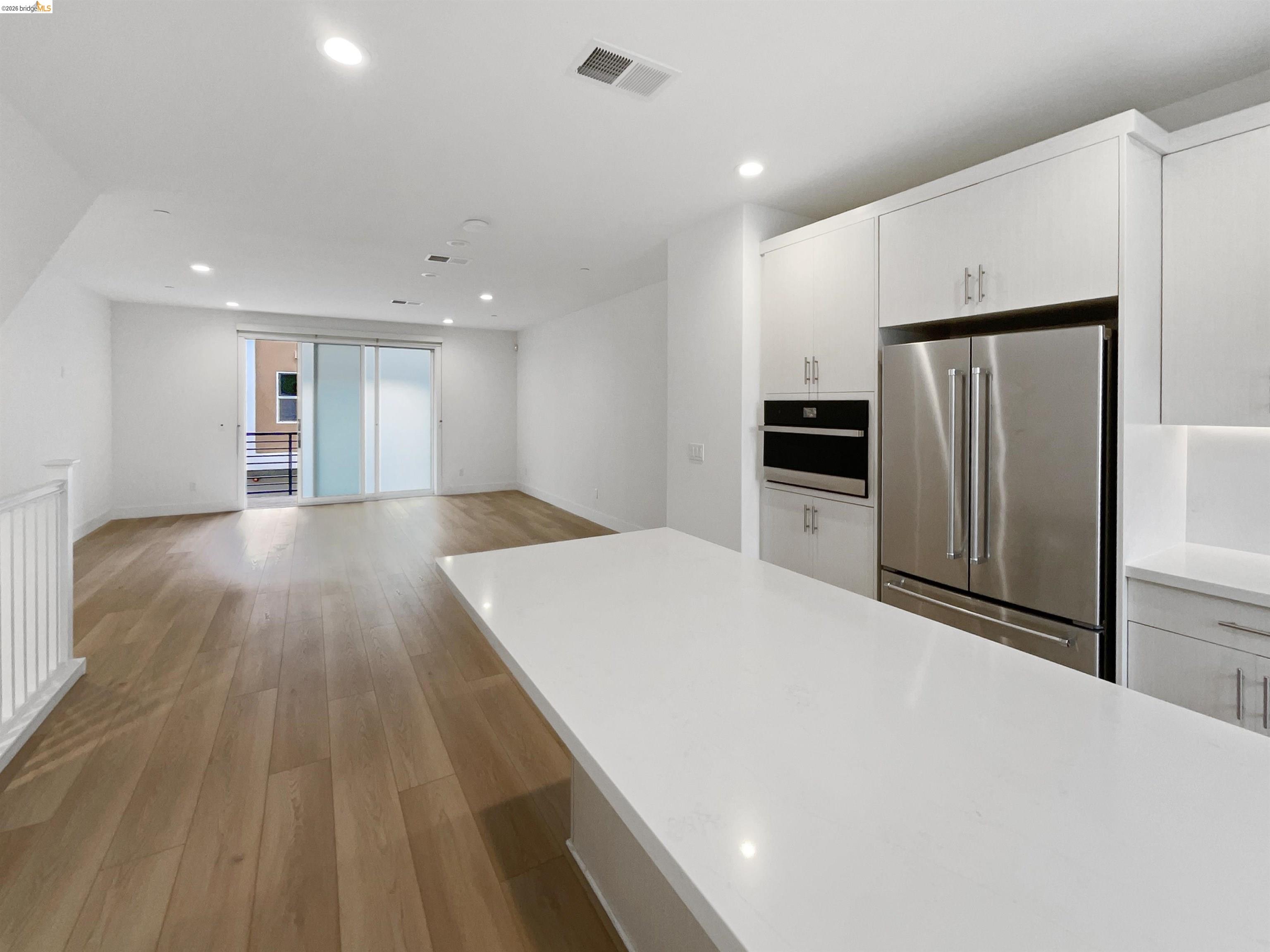 3419 Router Common Fremont, CA 94538 - Photo 26 of 26 Kitchen with freestanding refrigerator, recessed lighting, light wood-style floors, white cabinets, and open floor plan