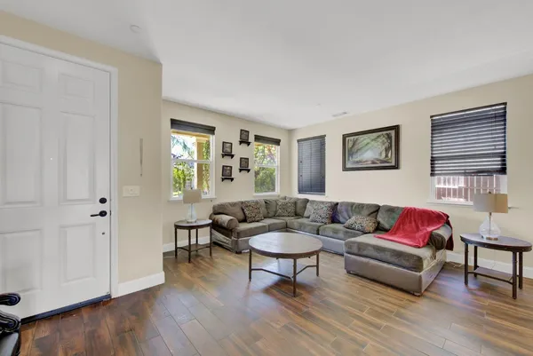 a living room with furniture and a wooden floor