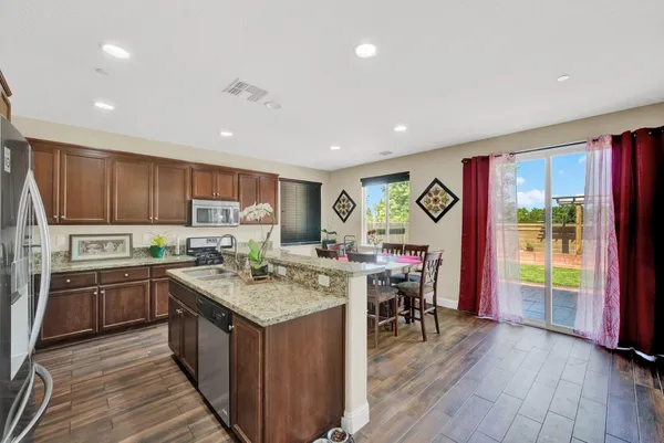 a kitchen with stainless steel appliances granite countertop a sink stove and cabinets