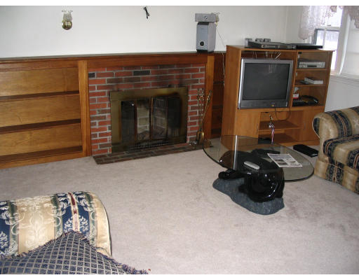 27 Chamberlain Road Chelmsford, MA 01824 - Photo 8 of 11 a living room with furniture and a fireplace