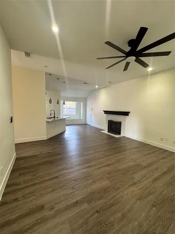 a view of empty room with wooden floor and a ceiling fan