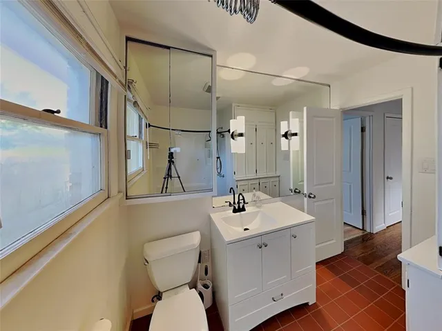 a bathroom with a sink and mirror with toilet