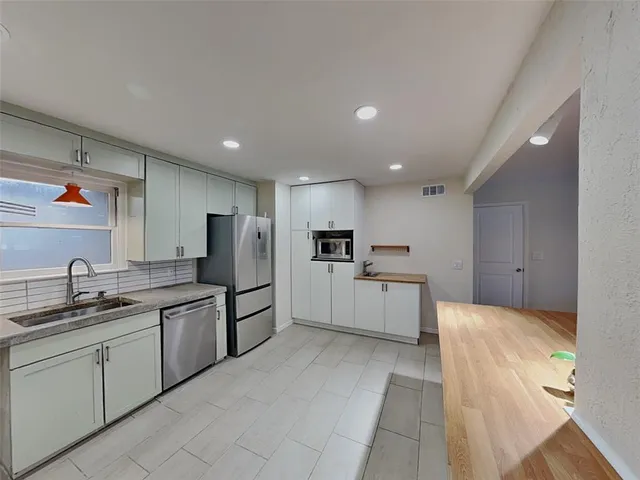 a large kitchen with cabinets and stainless steel appliances