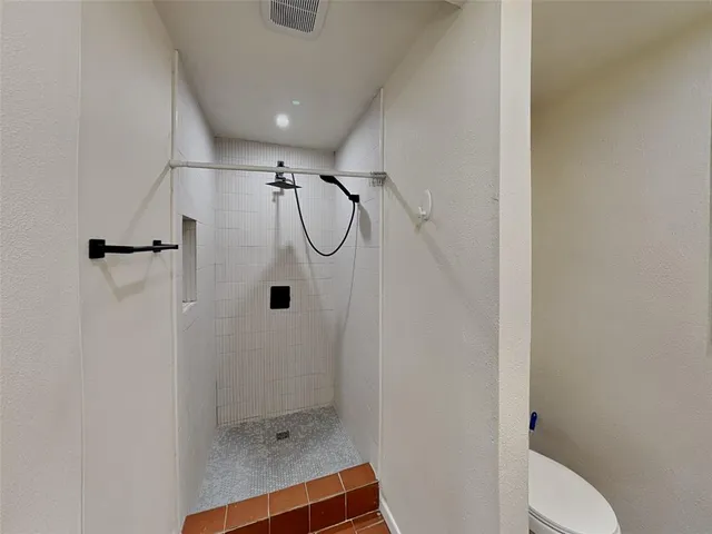 a bathroom with a shower and toilet