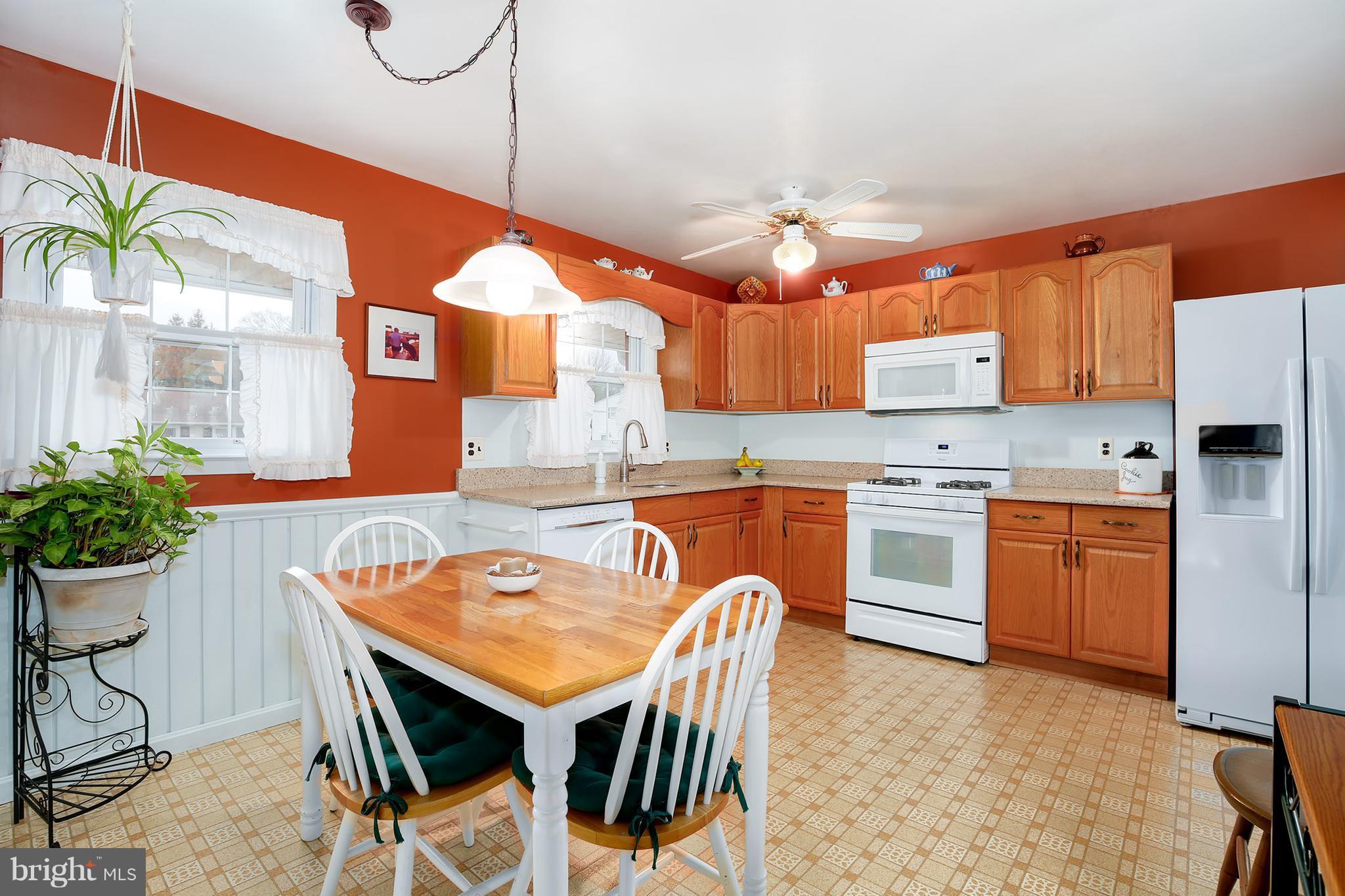 9007 Kilbride Road Baltimore, MD 21236 - Photo 11 of 30 a kitchen with stainless steel appliances granite countertop a stove a sink dishwasher a dining table and chairs with wooden floor