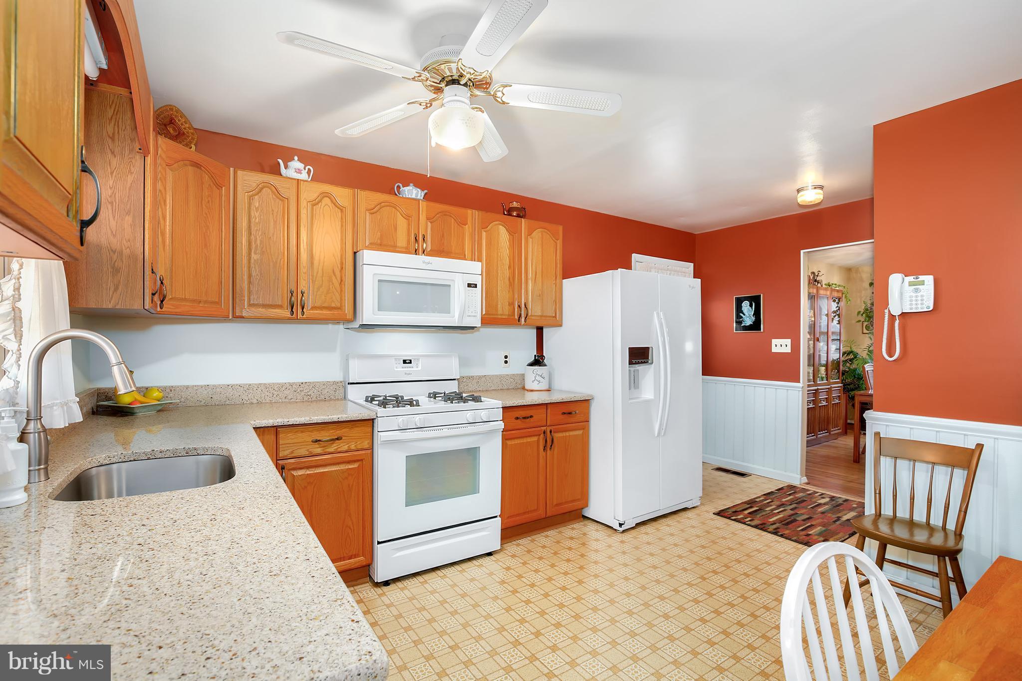9007 Kilbride Road Baltimore, MD 21236 - Photo 9 of 30 a kitchen with stainless steel appliances granite countertop a sink a stove a refrigerator cabinets and living room view