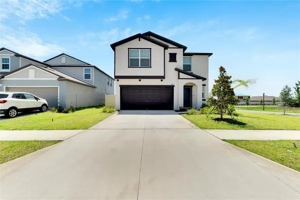 a front view of a house with a yard and garage