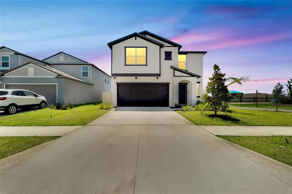 a front view of a house with a yard and garage