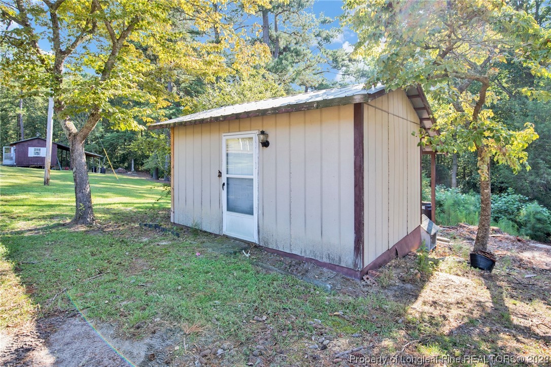 325 McIntosh Road Carthage, NC 28327 - Photo 26 of 30 a backyard of a house with outdoor seating and trees