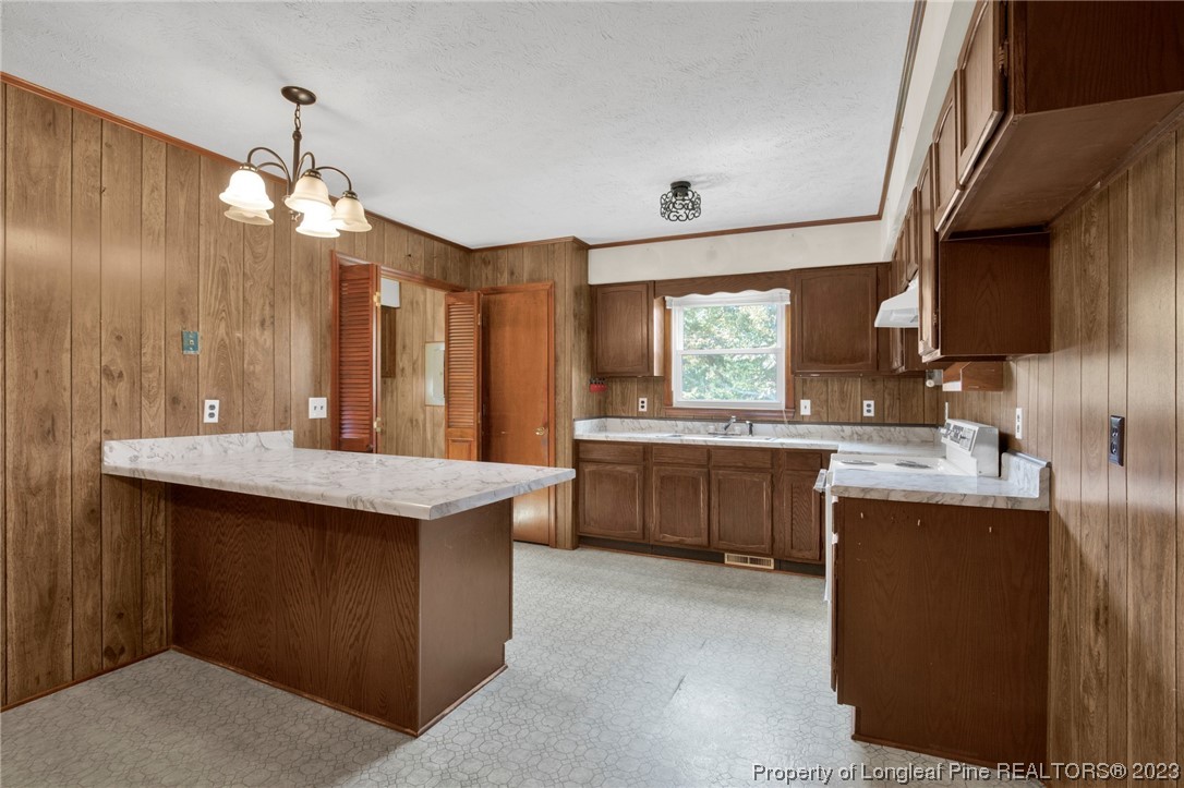 325 McIntosh Road Carthage, NC 28327 - Photo 8 of 30 a kitchen with kitchen island granite countertop a sink stove and wooden cabinets