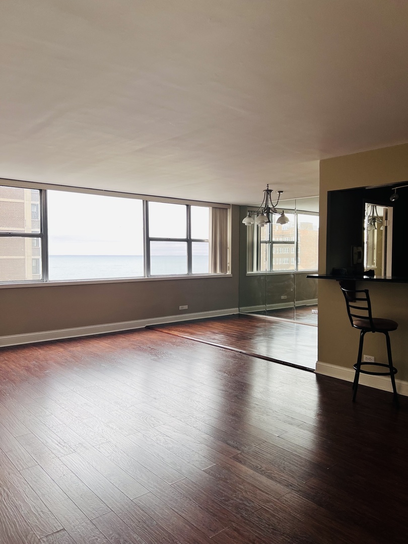 6301 North Sheridan Road, Unit 7O Chicago, IL 60660 - Photo 14 of 43 a view of an empty room with window and wooden floor