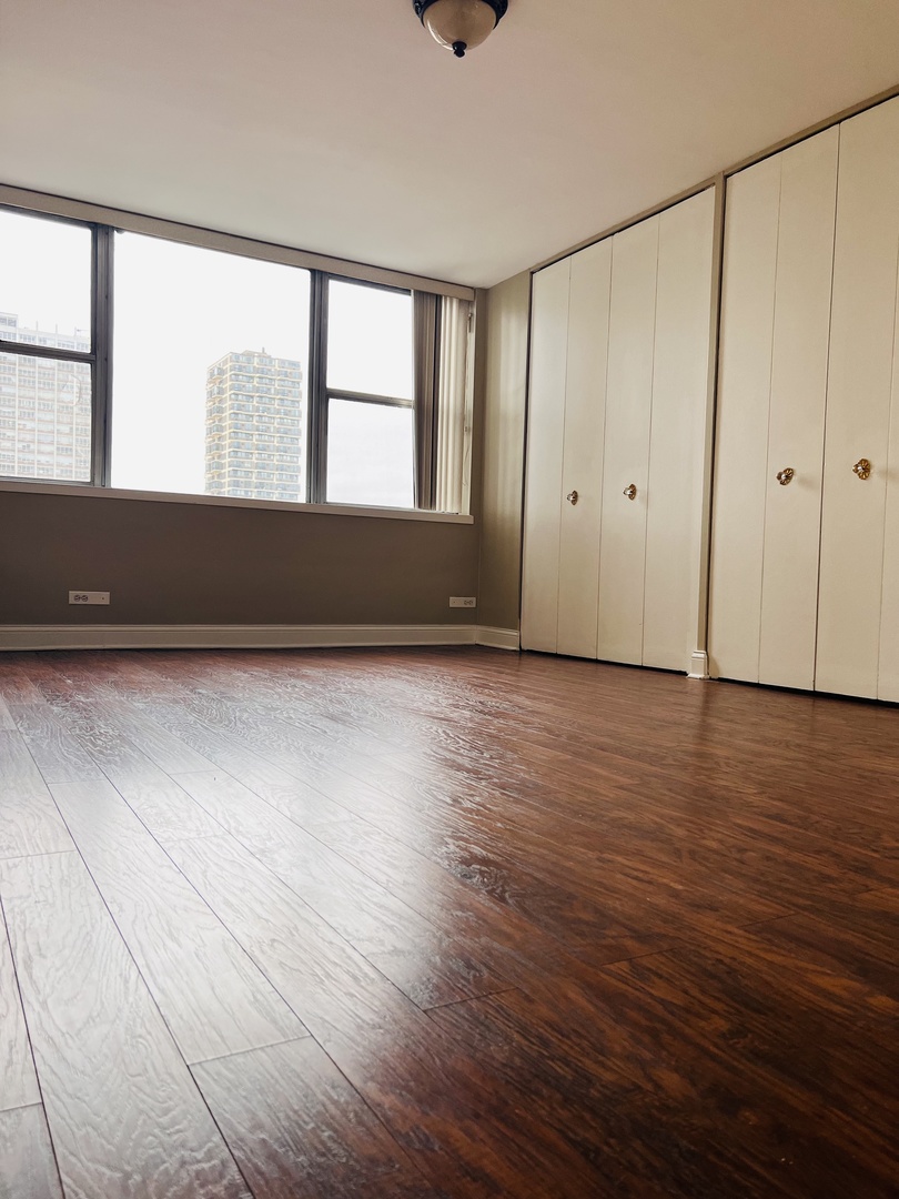 6301 North Sheridan Road, Unit 7O Chicago, IL 60660 - Photo 19 of 43 a view of an empty room with wooden floor and a window