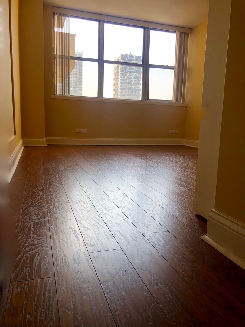 6301 North Sheridan Road, Unit 7O Chicago, IL 60660 - Photo 26 of 43 an empty room with wooden floor and windows