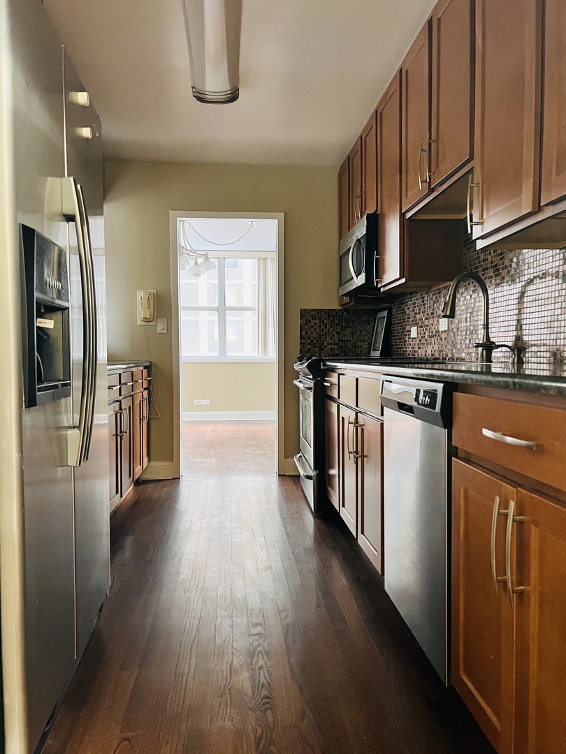 6301 North Sheridan Road, Unit 7O Chicago, IL 60660 - Photo 7 of 43 a kitchen with stainless steel appliances granite countertop a refrigerator a sink dishwasher a stove and a refrigerator with wooden floor