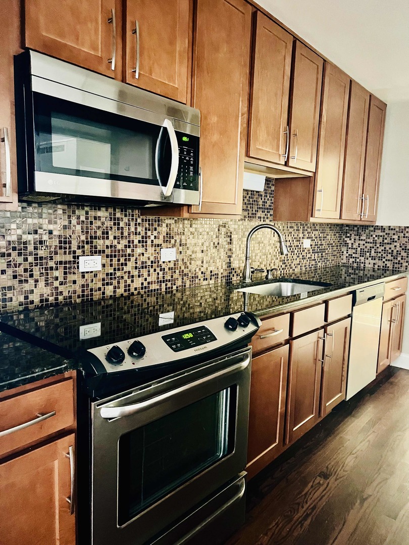 6301 North Sheridan Road, Unit 7O Chicago, IL 60660 - Photo 8 of 43 a kitchen with granite countertop cabinets stainless steel appliances and wooden floor