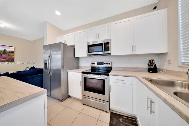 a kitchen with cabinets stainless steel appliances and a counter space