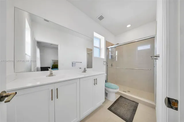 a bathroom with a double vanity sink toilet and shower