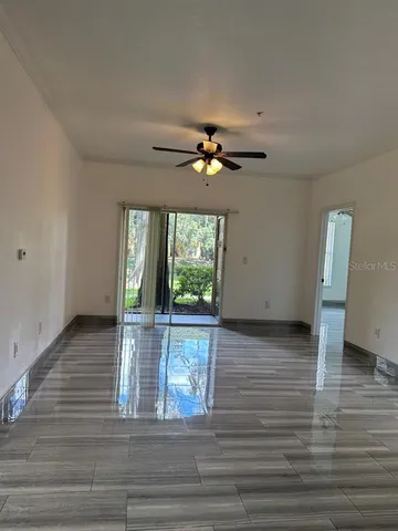 a view of an empty room with a window and wooden floor