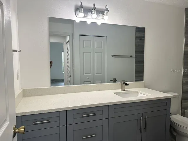 a bathroom with a sink vanity and a mirror