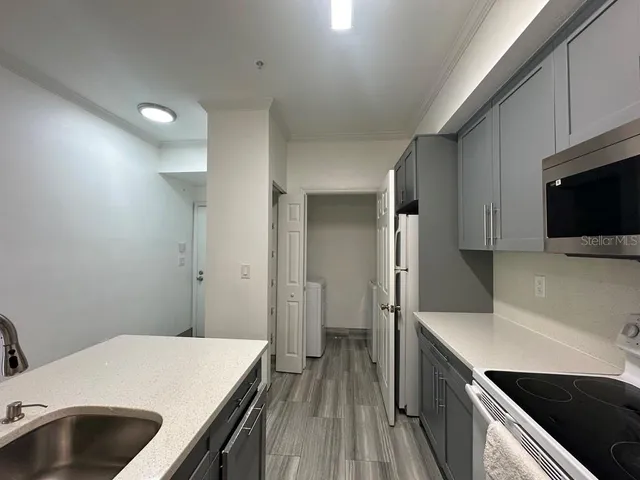 a kitchen with a sink and wooden floor