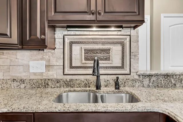 a kitchen with granite countertop a sink and cabinets
