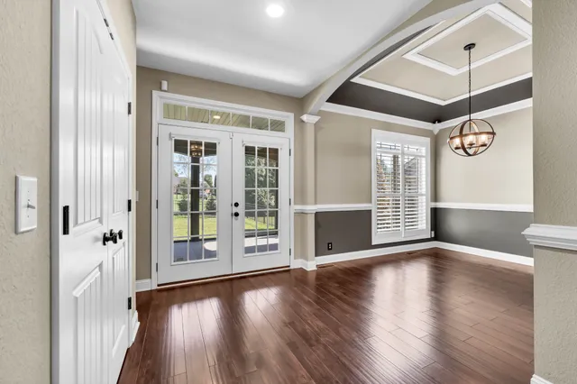 a view of a hallway with wooden floor and a large window