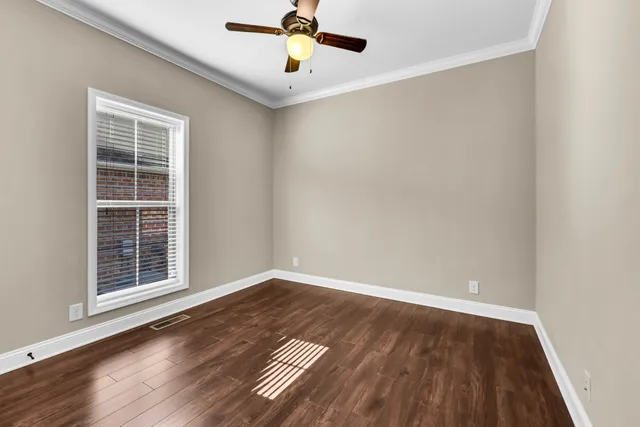 a view of an empty room with wooden floor