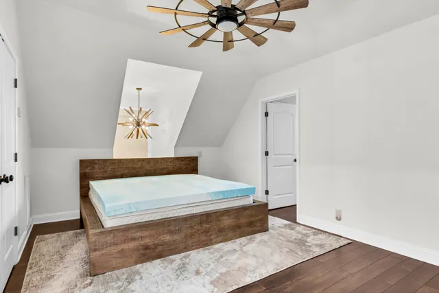 a bedroom with a bed and a chandelier