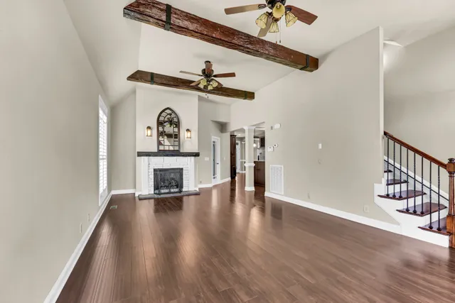 a view of a hallway with wooden floor a fireplace and a window