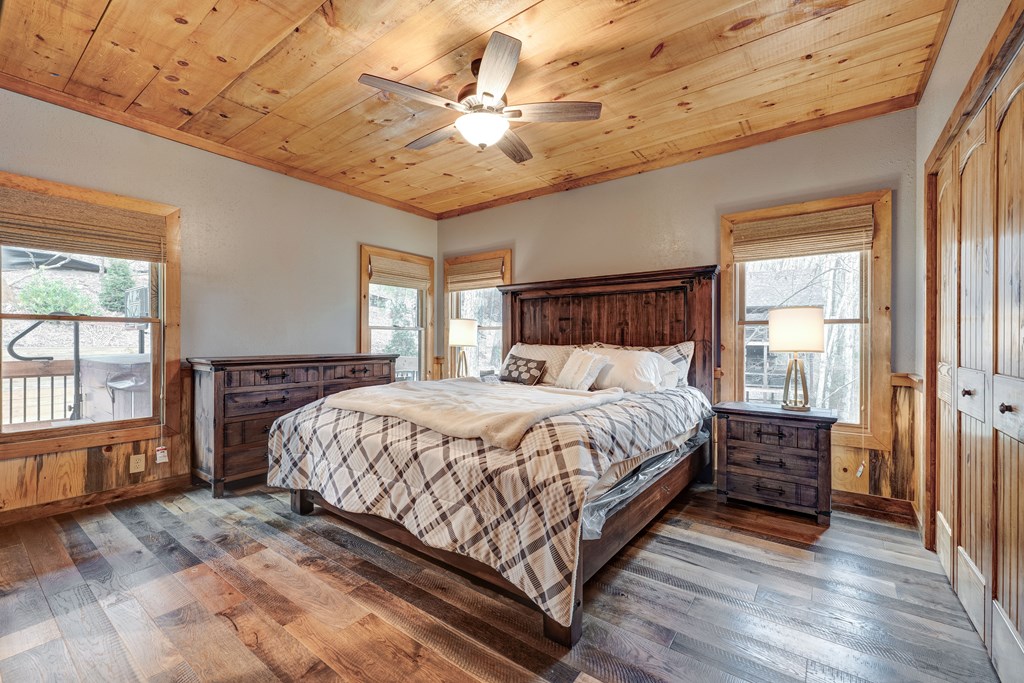 1601 Shady Falls Road Blue Ridge, GA 30513 - Photo 22 of 78 a bedroom with a large bed a chandelier and windows