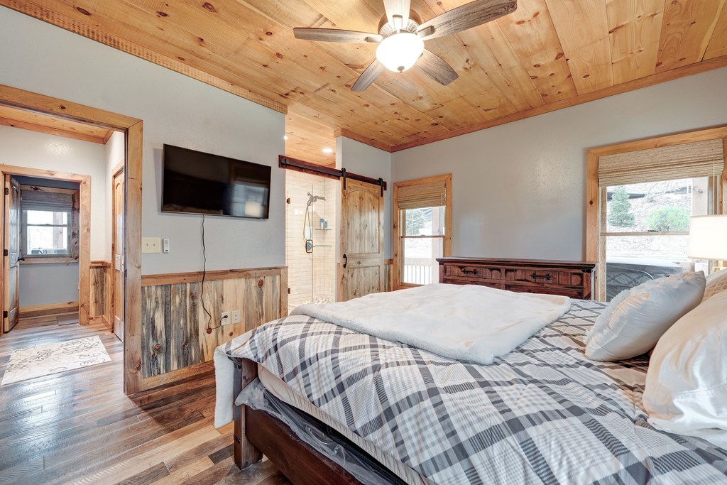 1601 Shady Falls Road Blue Ridge, GA 30513 - Photo 25 of 78 a bedroom with a large bed a flat tv screen and a walk in closet