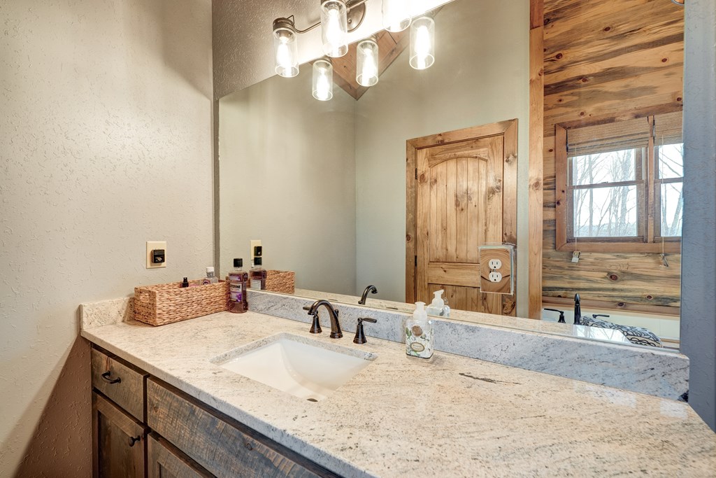 1601 Shady Falls Road Blue Ridge, GA 30513 - Photo 41 of 78 a bathroom with a granite countertop sink and a mirror
