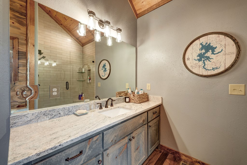 1601 Shady Falls Road Blue Ridge, GA 30513 - Photo 42 of 78 a bathroom with a granite countertop sink and a mirror