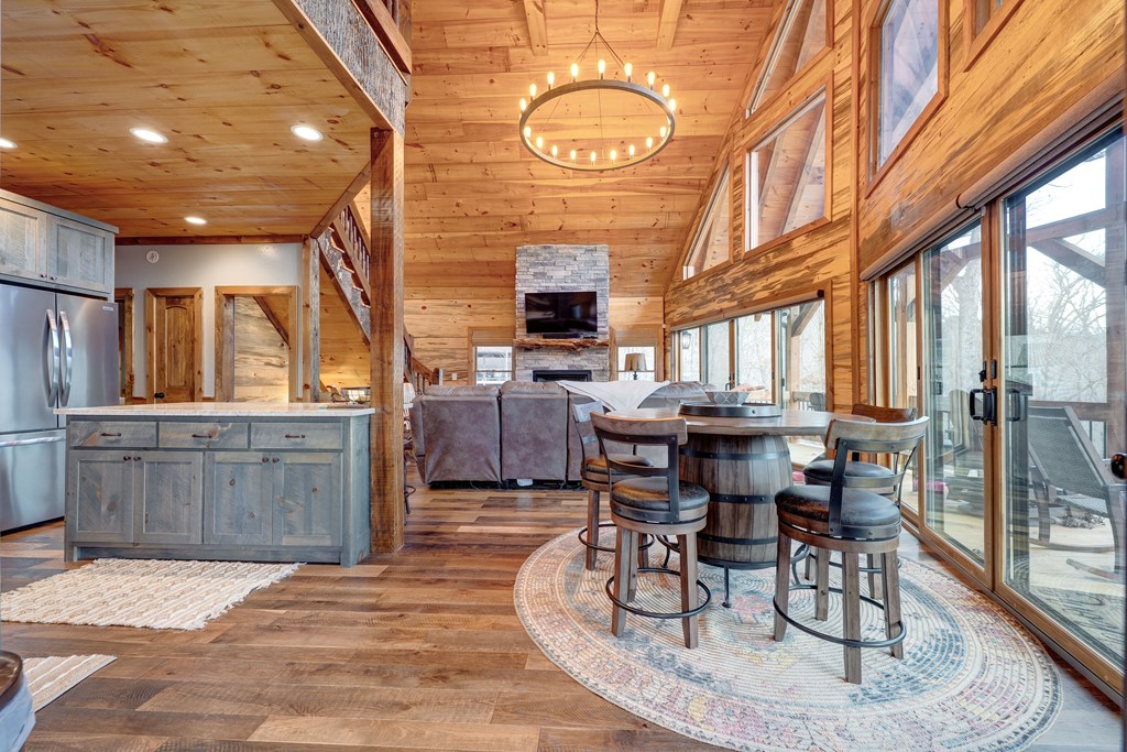 1601 Shady Falls Road Blue Ridge, GA 30513 - Photo 7 of 78 a living room with furniture a fireplace and a floor to ceiling window