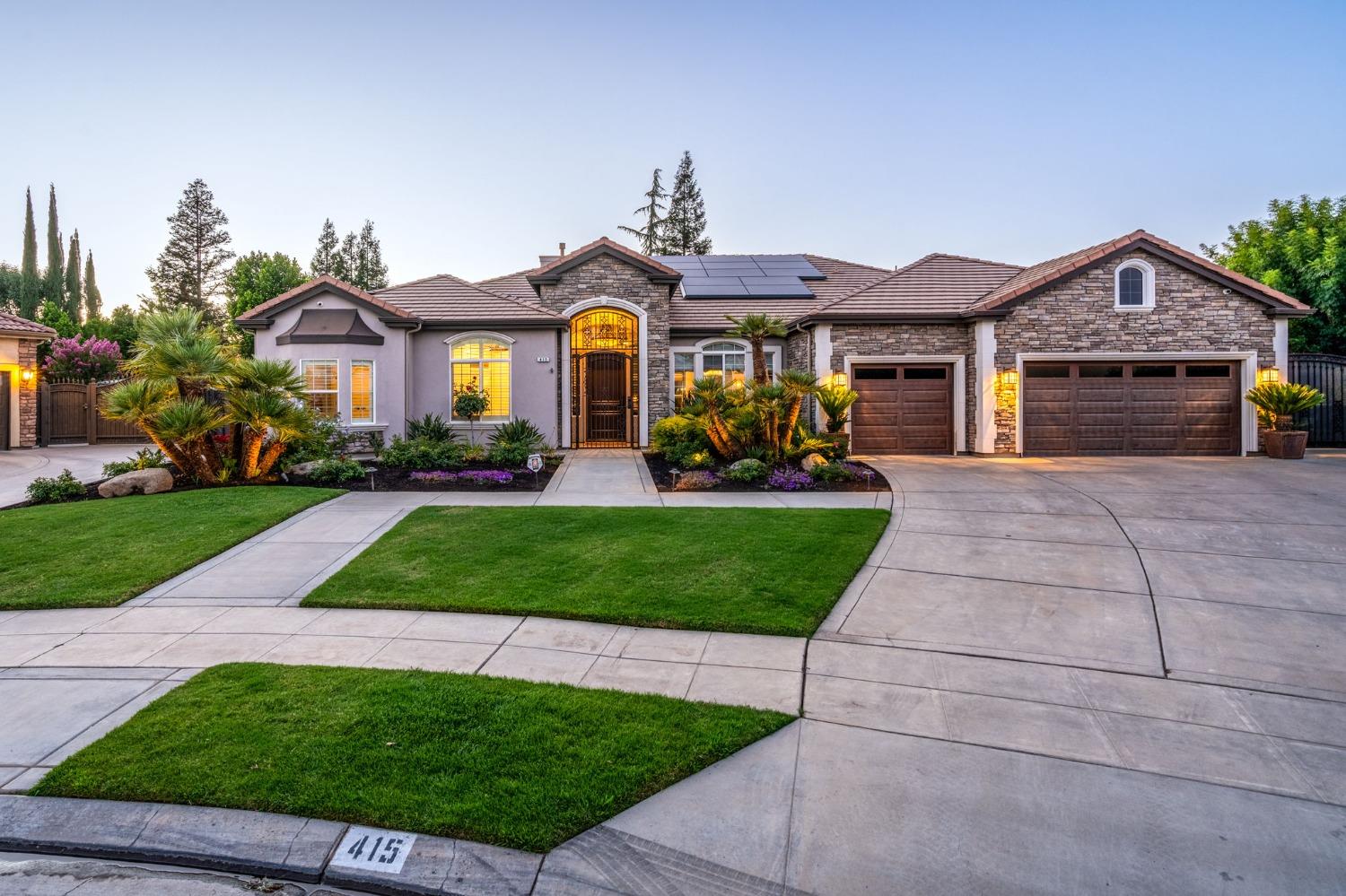 a front view of a house with a yard and potted plants