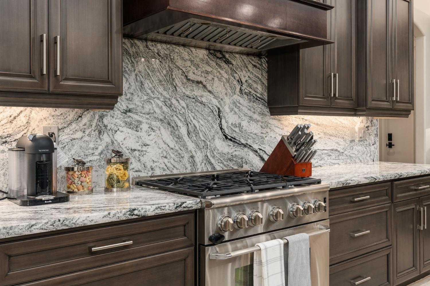415 Heritage Avenue Clovis, CA 93619 - Photo 12 of 56 a kitchen with granite countertop a stove and a sink