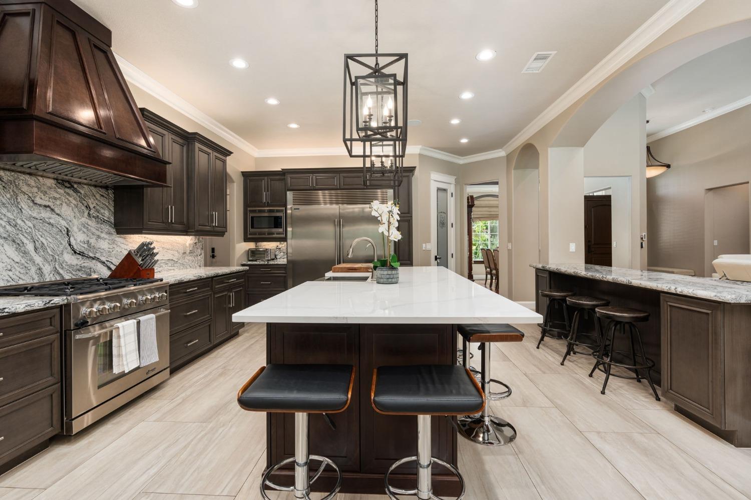 415 Heritage Avenue Clovis, CA 93619 - Photo 9 of 56 a kitchen with stainless steel appliances kitchen island granite countertop a table chairs sink and cabinets