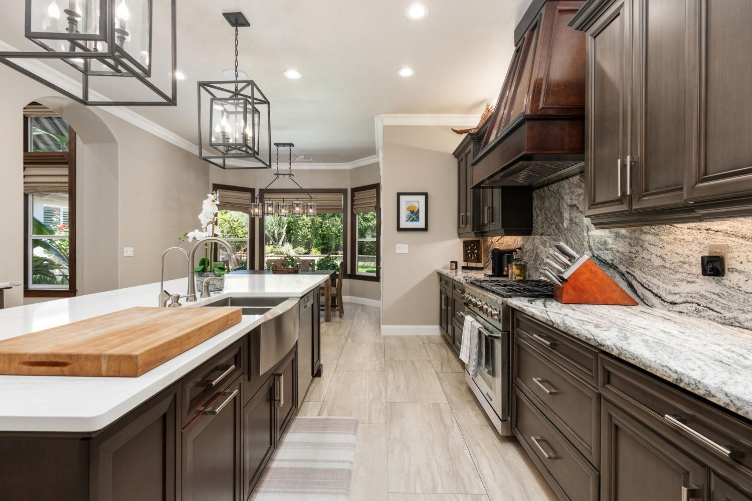 415 Heritage Avenue Clovis, CA 93619 - Photo 10 of 56 a kitchen with stainless steel appliances granite countertop a sink a stove and a wooden floors