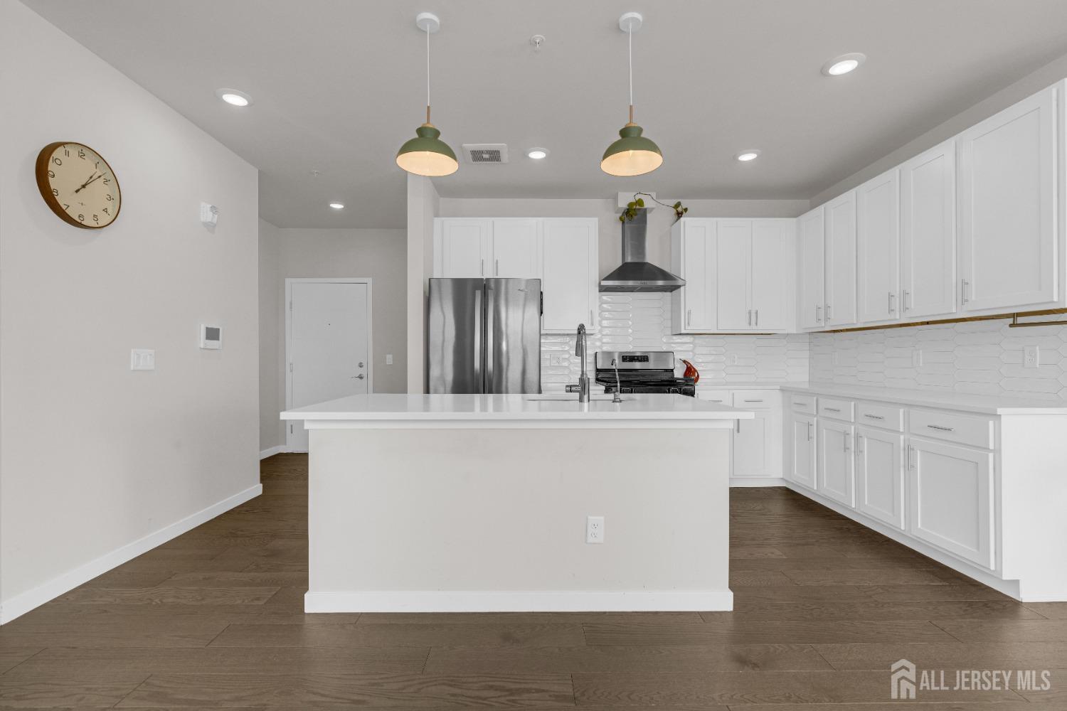 237 Lorhan Drive, Unit 237 Piscataway, NJ 08854 - Photo 3 of 44 a large white kitchen with a refrigerator a stove a sink dishwasher and white cabinets with wooden floor