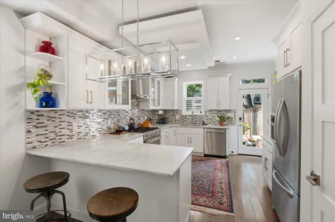a kitchen with granite countertop stainless steel appliances a stove sink and cabinets