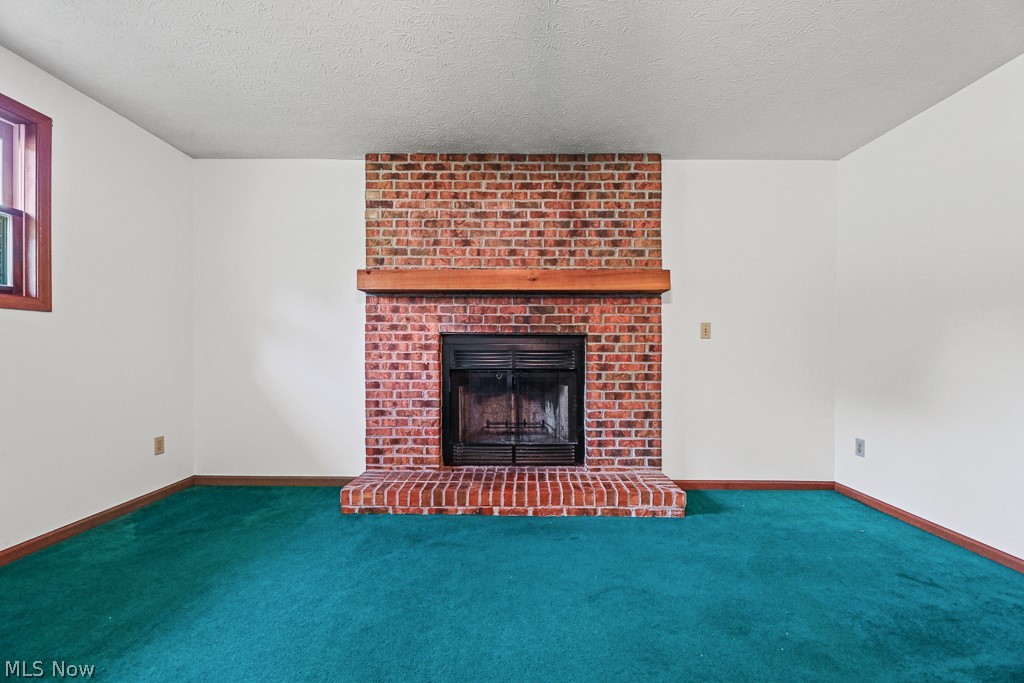 2642 Blake Road Wadsworth, OH 44281 - Photo 12 of 46 Brick fireplace with a wood mantle and raised hearth, light walls, and green carpeting