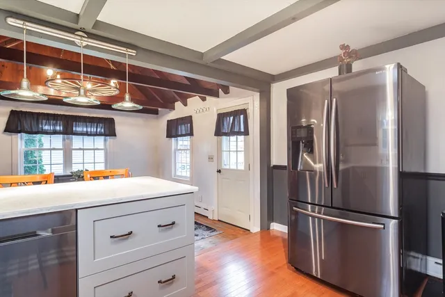 a kitchen with stainless steel appliances a refrigerator and wooden floor