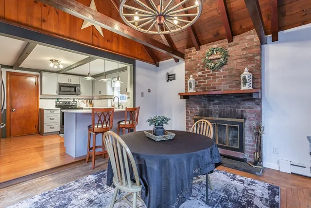 a dining room with furniture a fireplace and wooden floor